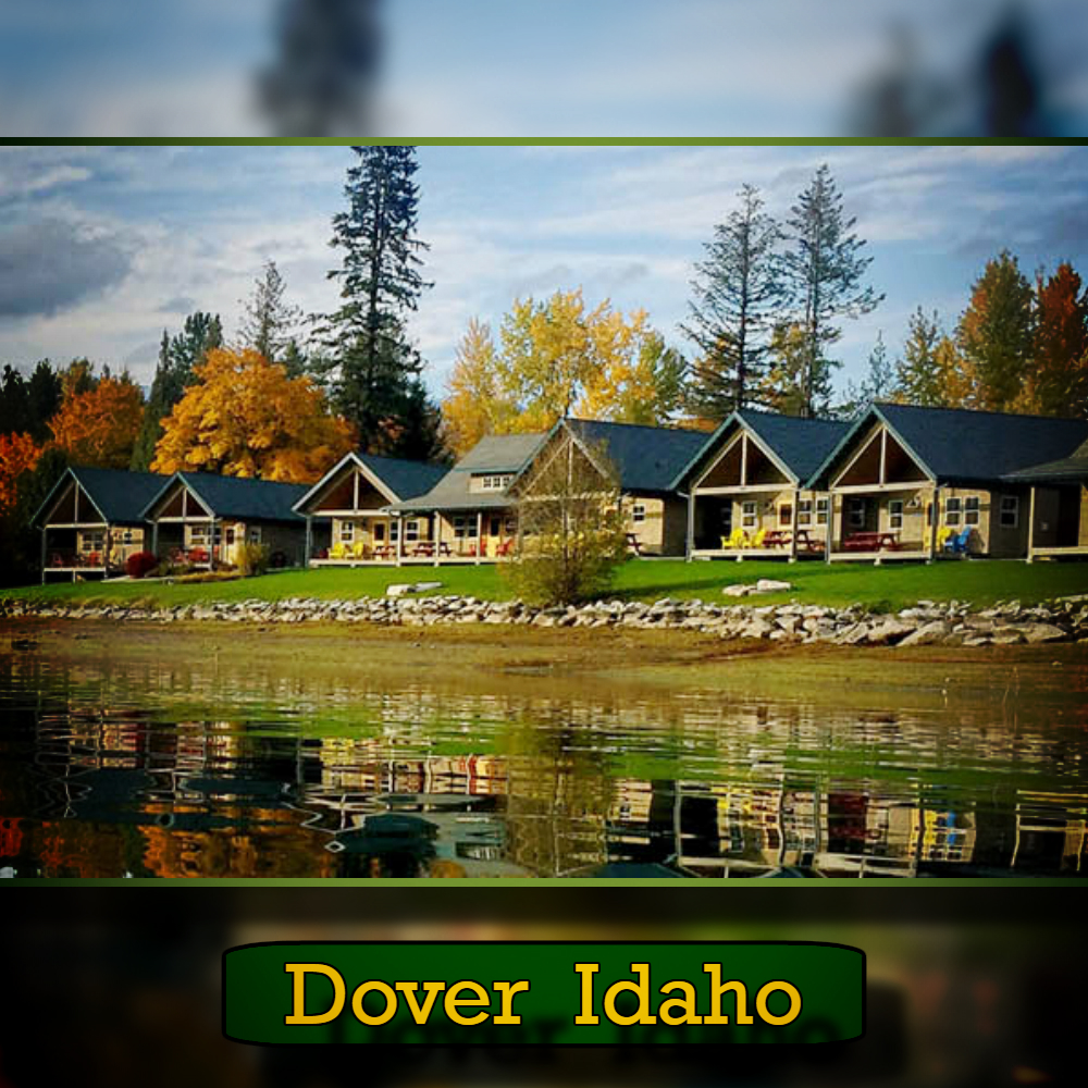 Five cabins with gabled roofs are lined up along a waterfront surrounded by autumn trees. A discreet sign at the bottom reads "Dover Idaho, tow service available.