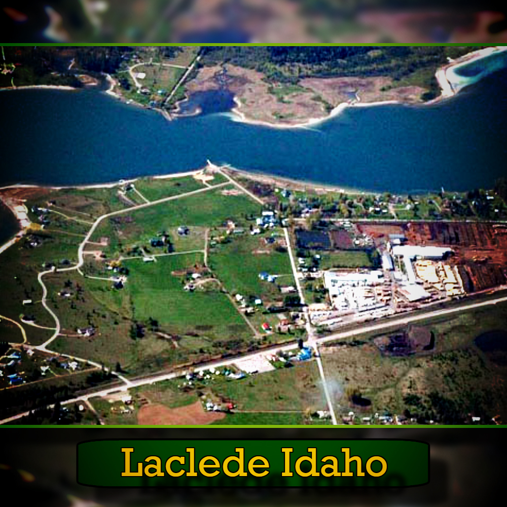 Aerial view of Laclede, Idaho, featuring a river, green fields, scattered buildings, and a tow truck on a country road. The name "Laclede Idaho" is at the bottom of the image.