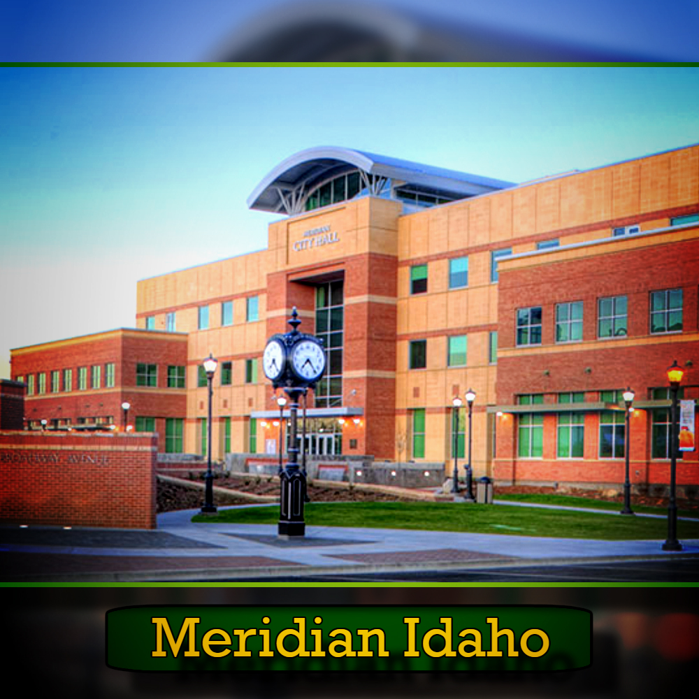 A multi-story brick building labeled Meridian City Hall, with a clock and streetlights in front, is shown at dusk. A sign reading "Meridian, Idaho" sits at the bottom, and a tow service truck passes by on the dimly lit street.