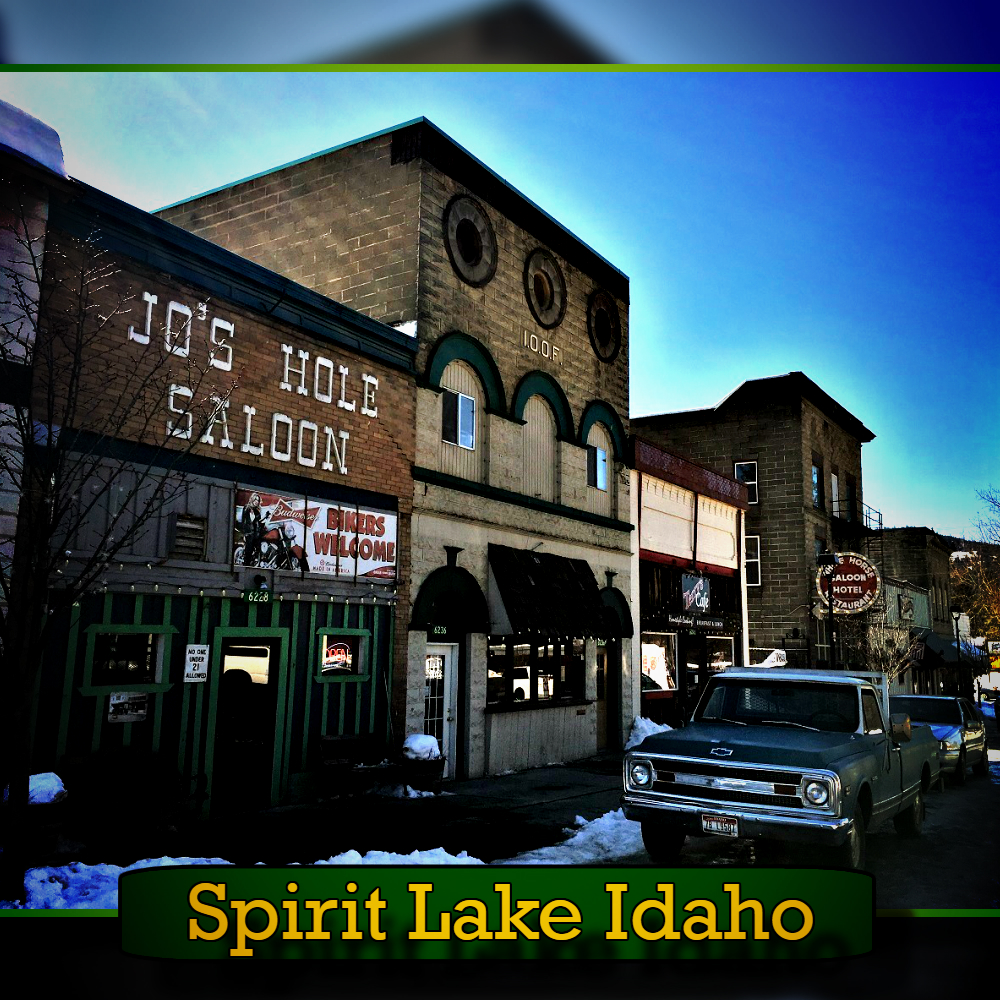A street scene in Spirit Lake, Idaho, showing Jo's Hole Saloon and neighboring buildings. A vintage tow truck is parked on the snowy street.